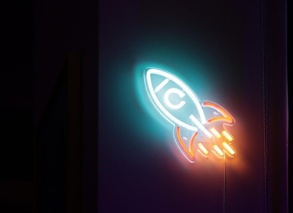 a neon sign with a rocket ship on it