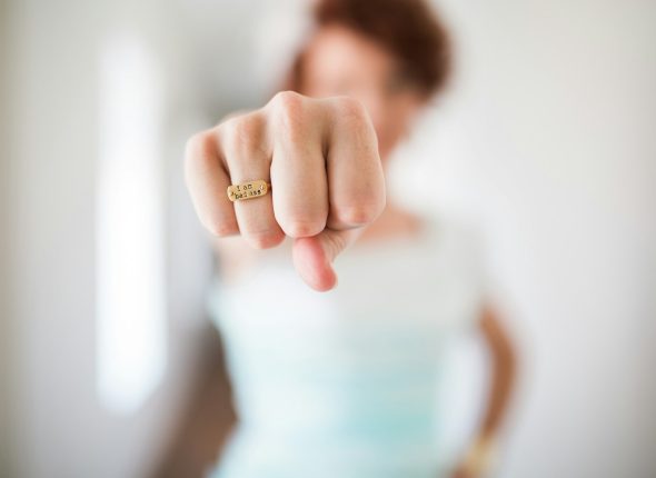 woman showing gold-colored ring