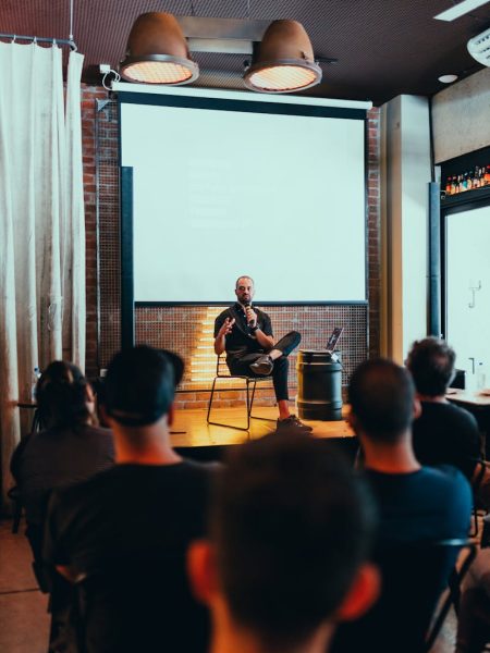 Speaker engages an audience during a business seminar in a modern conference room.